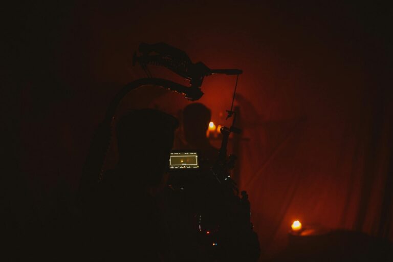 An atmospheric film set featuring a silhouetted cameraman filming by candlelight.