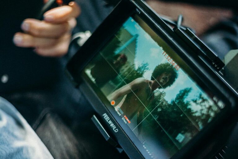 Close-up of a cinematic display showing a filmmaker at work capturing a scene outdoors.